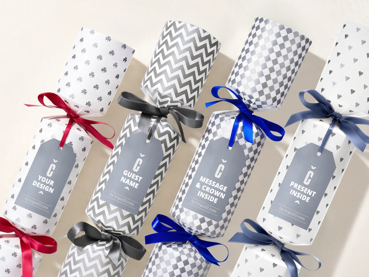 Vier personalisierbare Hope22 Knallbonbons mit Mustern, bunten Schleifen und Logo-Anhängern – Firmengeschenke mit eigenem Design